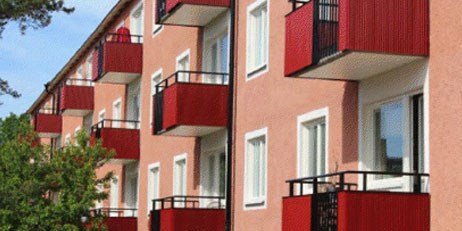 Rosa lägenhetshus med röda balkonger